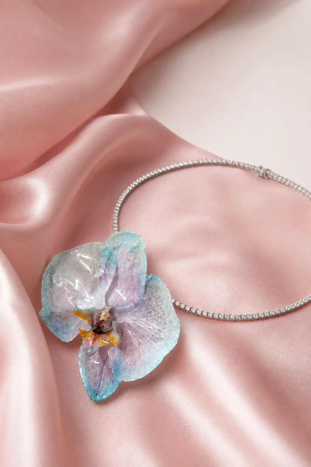 A real blue and pink orchid preserved in resin and arranged with a silver tennis necklace